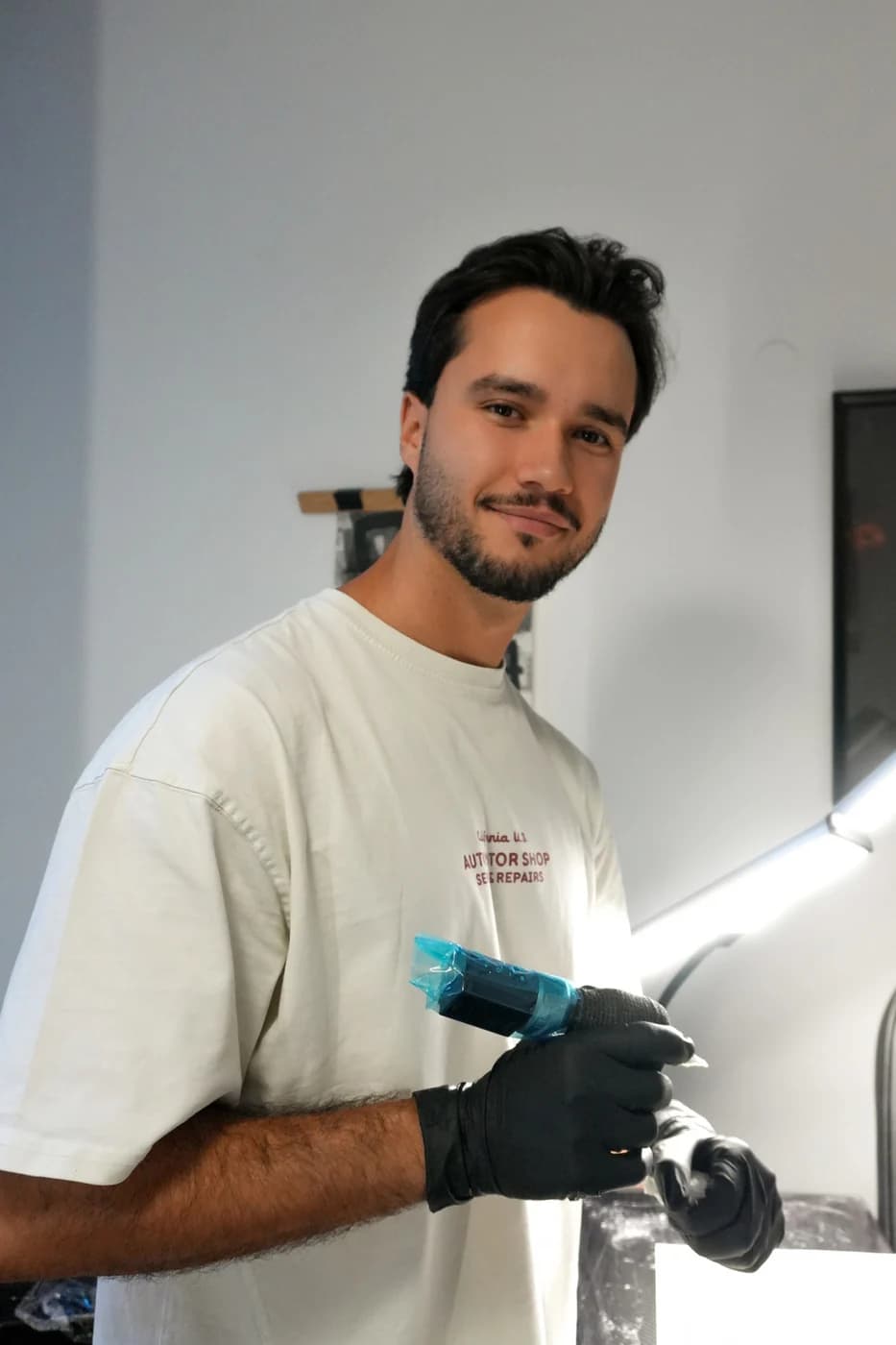 Daniel Santos de frente para a câmara, com a máquina de tatuar na mão.