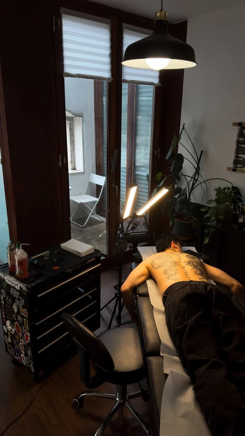 Uma sessão de tatuagem junto à janela do AURUM.