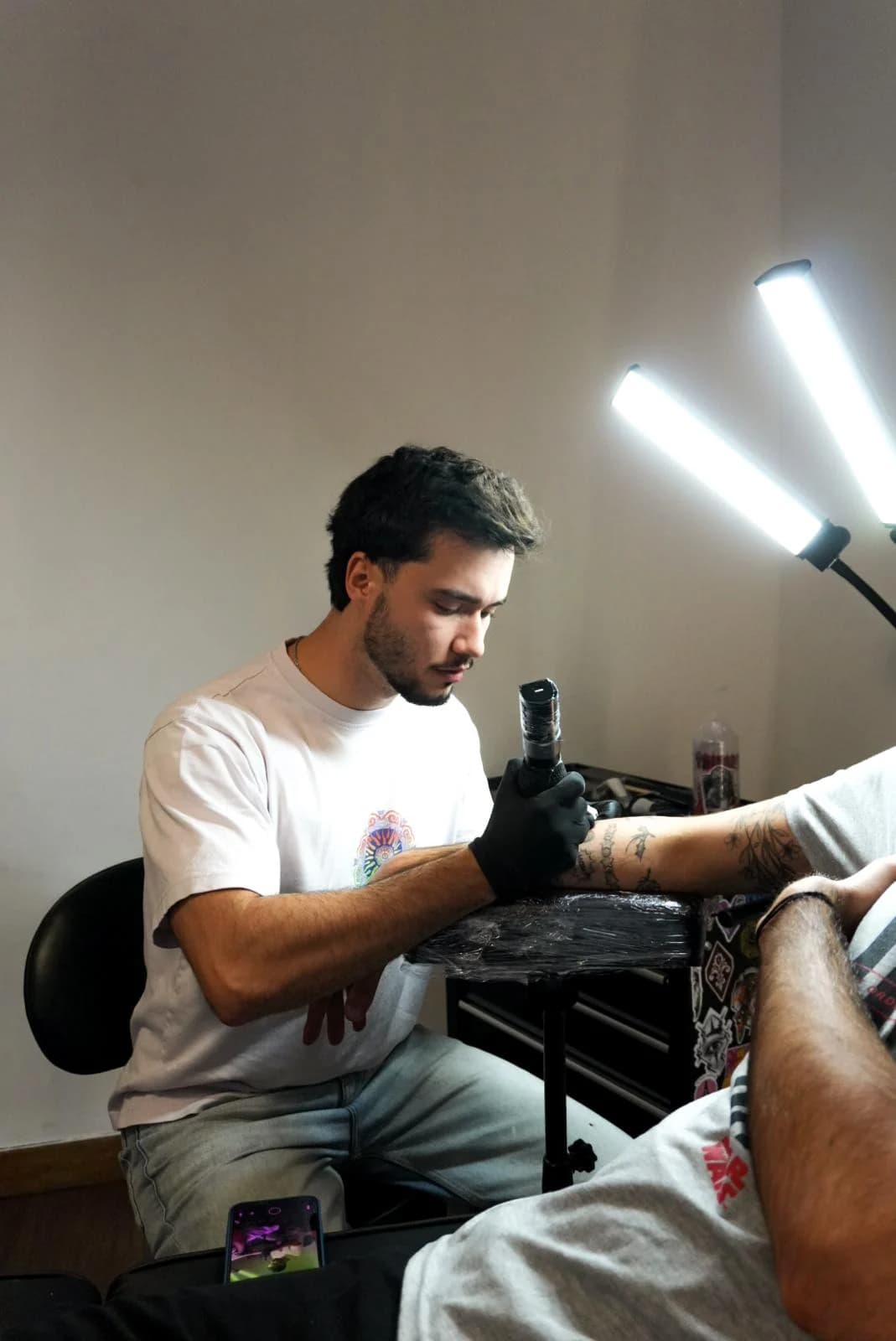 Daniel concentrado numa sessão de tatuagem no estúdio.