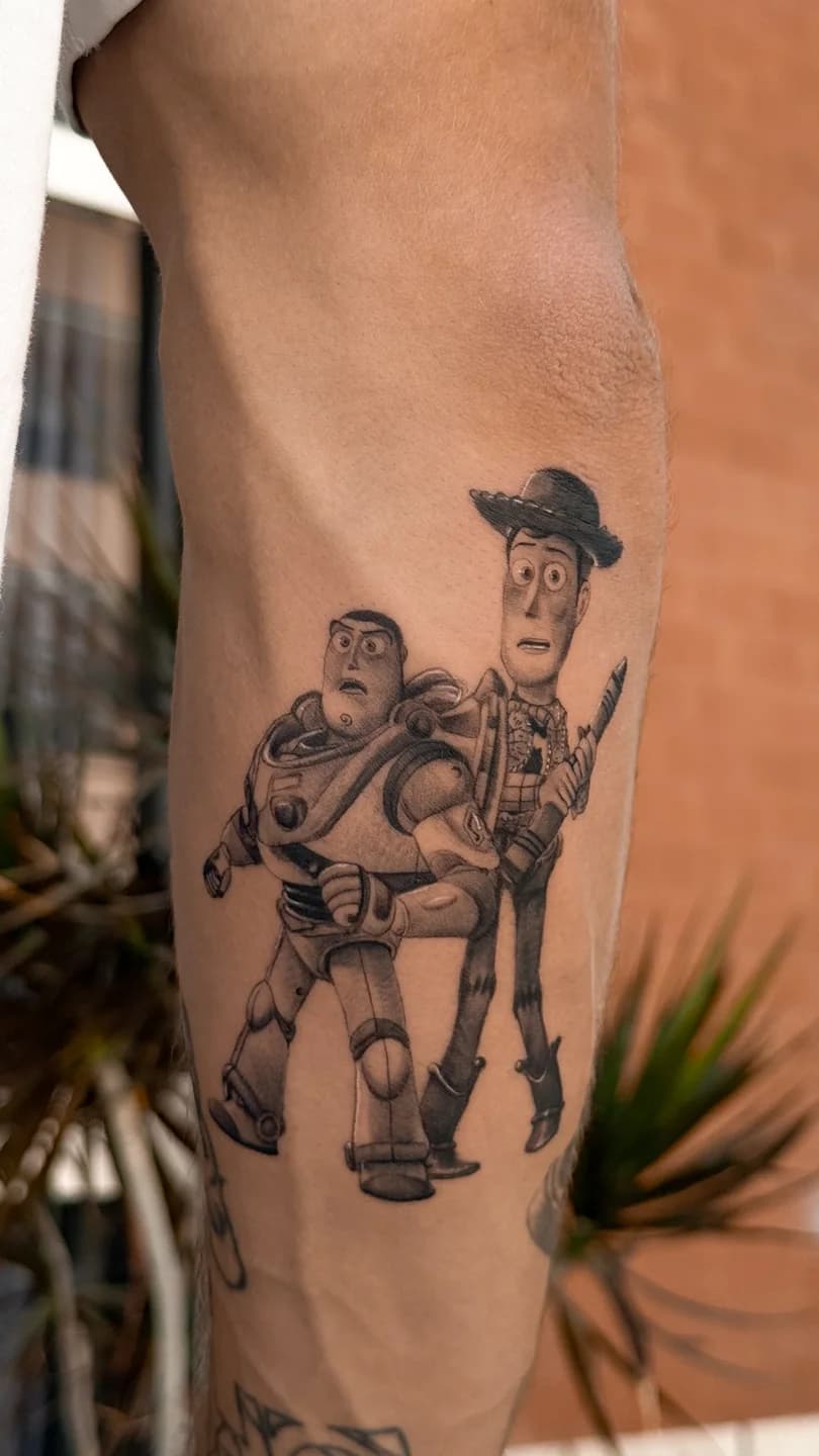 Tatuagem de Woody e Buzz Lightyear no braço.