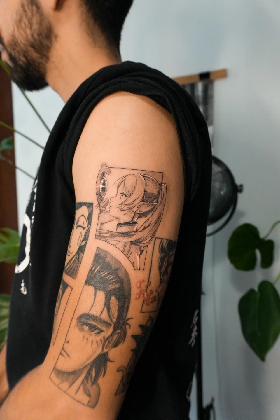 Composição de personagens de anime tatuada no braço.